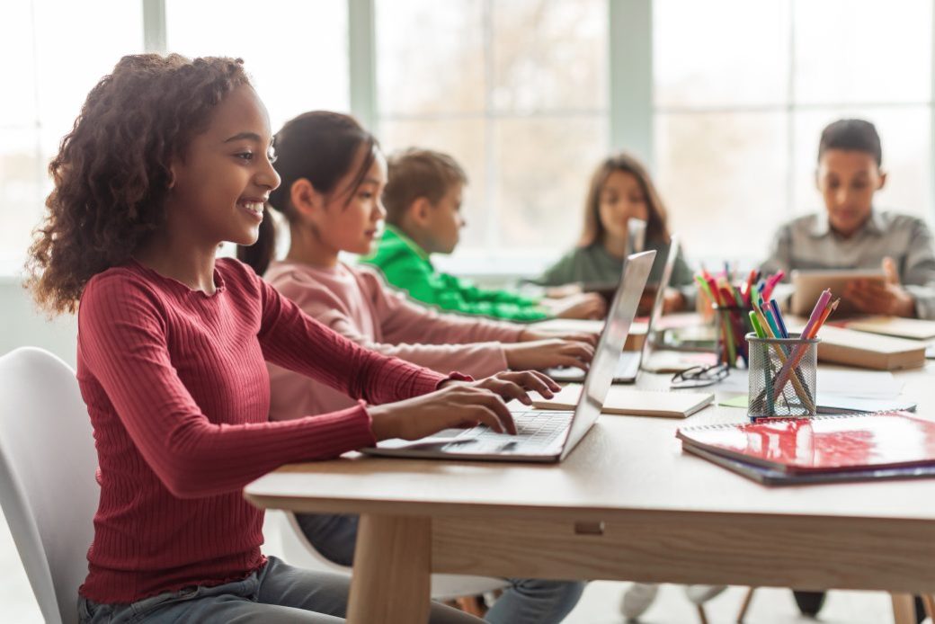 bigstock-Black-Schoolgirl-Using-Laptop-461062205-1040x693