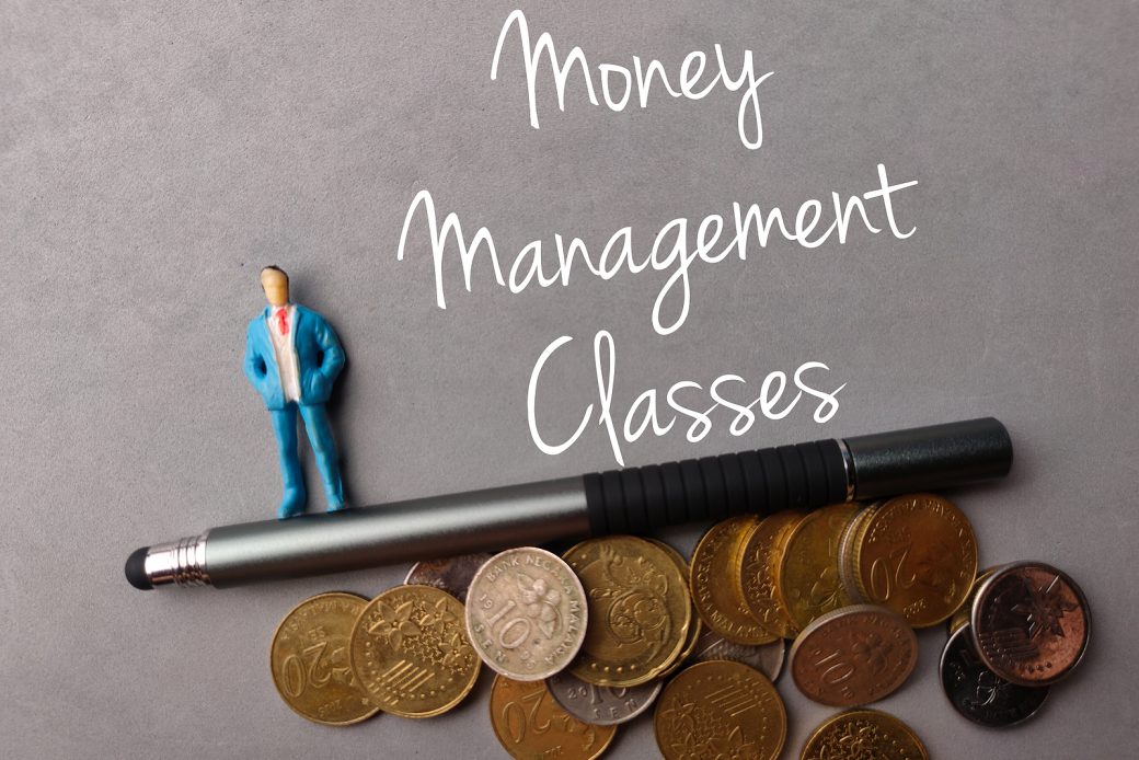 Miniature people,coins and pen with text Money Managment Classes on a gray background.