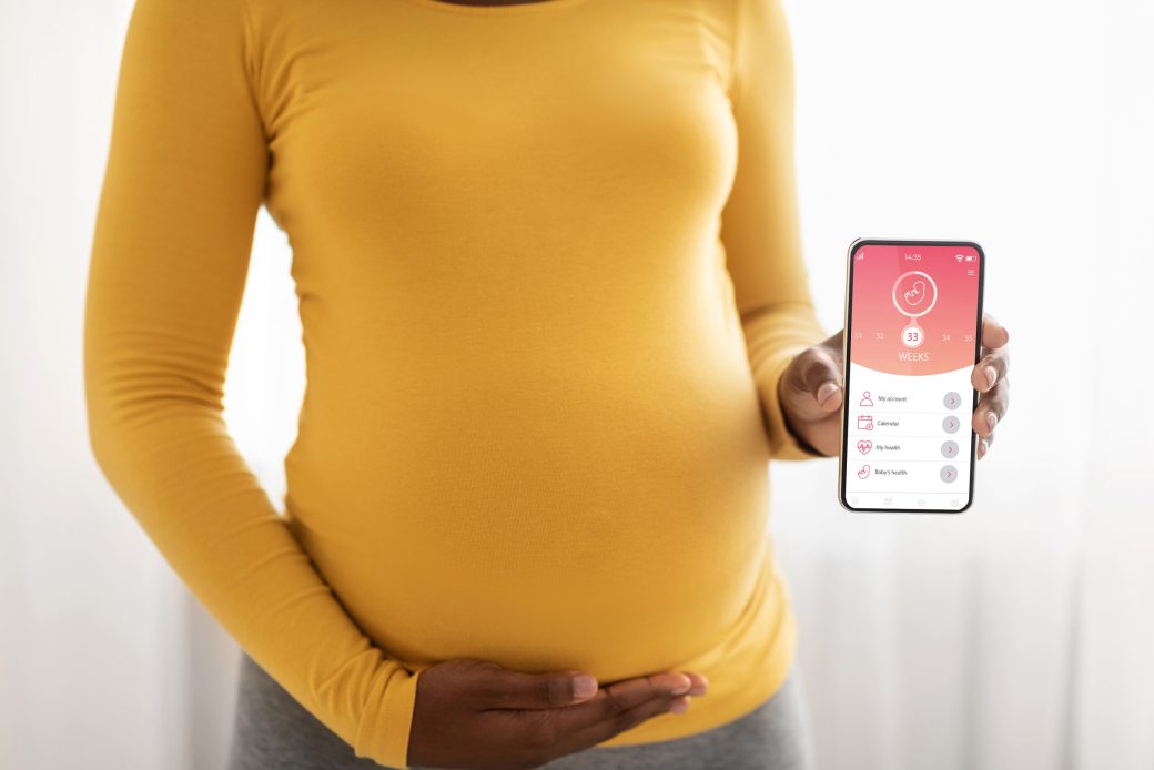 Pregnant woman showing mobile application for pregnancy